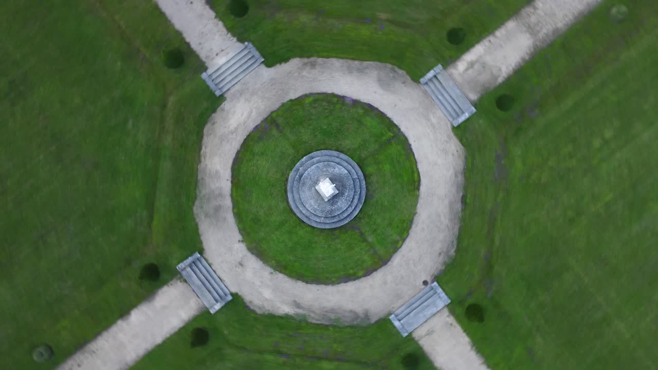 Flying doing circles around a statue in a park, zenital view by drone
