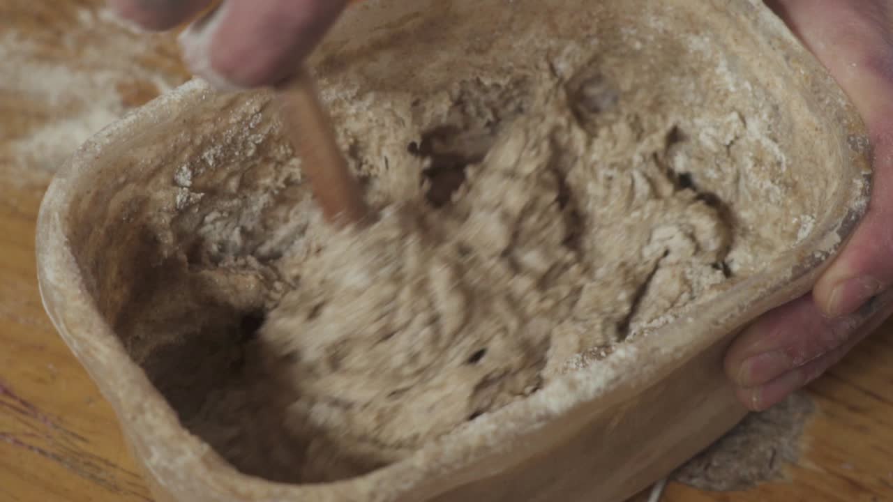 나무 숟가락으로 용기에 빵 반죽 혼합물을 혼합 - slowmo를 닫습니다