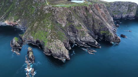 drone video flying towards slieve league, ireland at sunset and panning down