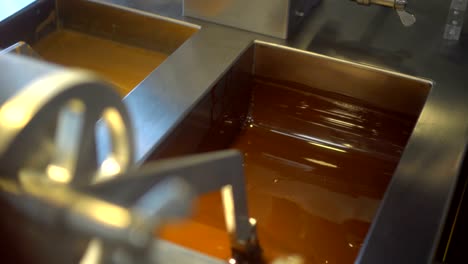 la máquina agita el chocolate de leche líquido en el bucle de la máquina industrial.