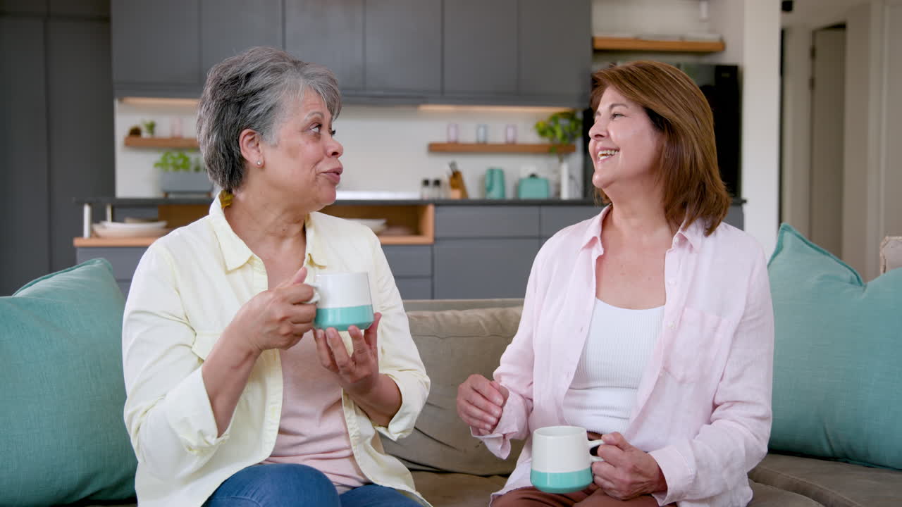Senior women enjoying coffee and conversation at home, sharing joyful moments