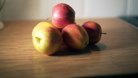 manzanas rojas en el movimiento de la encimera de la cocina de madera de derecha a izquierda