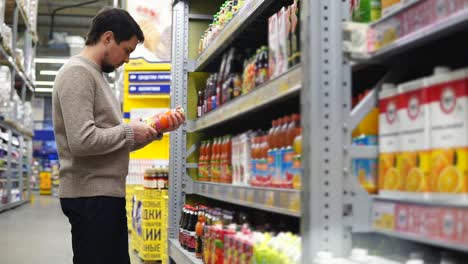 hombre comprando bebidas en una tienda de comestibles