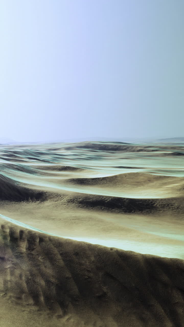 Waves of sand stretch across an open desert under a clear sky