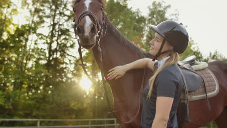 es un día soleado con un caballo encantador. una mujer de caballos está acariciando a su caballo marrón. estos son sentimientos increíbles y tiernos.