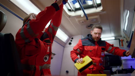 paramedics preparing medical equipment for first aid in ambulance car