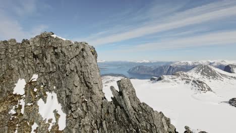 Persona-Escalando-Una-Montaña-Rocosa-Extremadamente-Peligrosa-En-Noruega,-Vista-Aérea