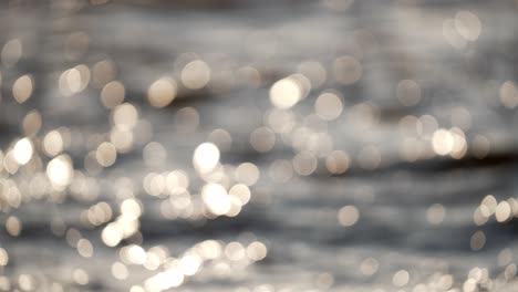 bokeh de enfoque superficial disparó la superficie del océano brillante de gran apertura en la hora dorada
