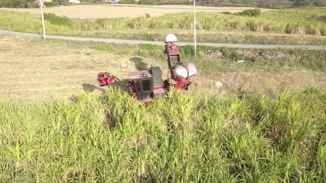 closeup of sugar cane harvester as it moves through field