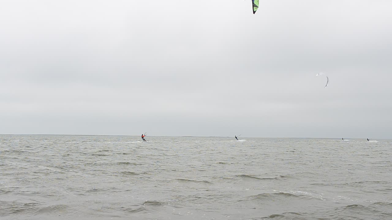 Skysurf em tempo ventoso. Deslizando em uma prancha sob uma vela.