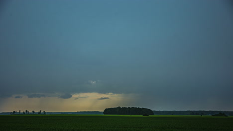 Moving-cloudy-sky-misty,-patch-of-light-from-the-sun-in-the-sky,-green-field