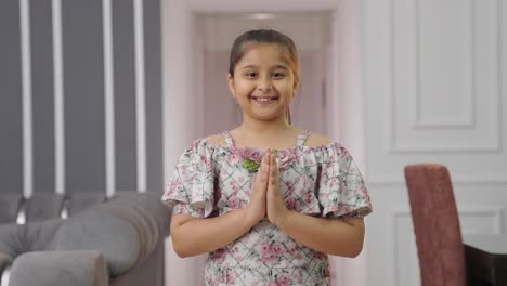 polite indian kid girl doing namaste and greeting