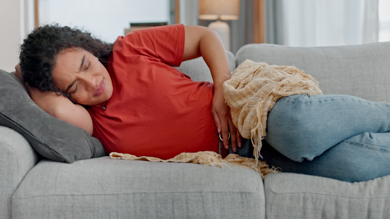 Stomach ache, stress and woman on a sofa with pms