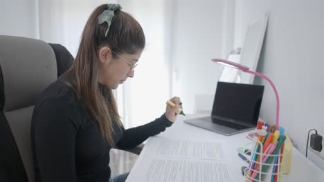mujer joven estudiando en casa