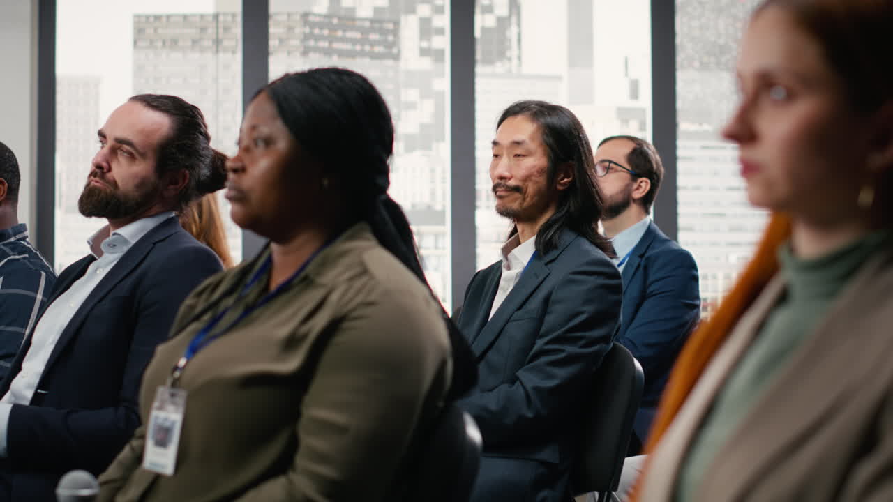 Asian businessman listening to presentation with diverse audience group
