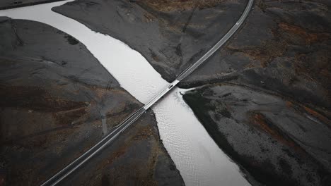 Ring-road-Iceland,-aerial-car-driving-over-bridge-and-river,-flying-over-nature-mountain-beautiful-scenery