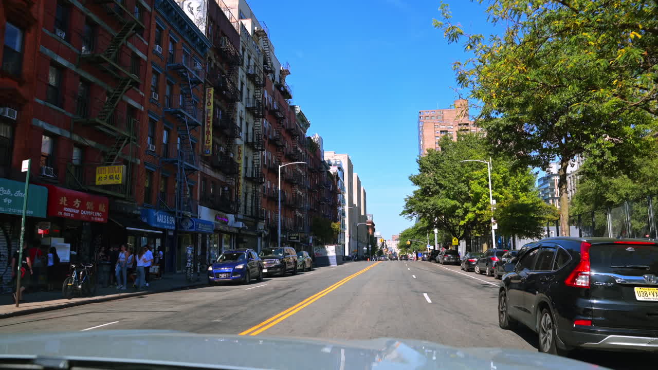 New York, USA, 9 August 2025: Lower East Side street in Manhattan. Historic tenements, shops, and traffic line a sunny Lower East Side avenue