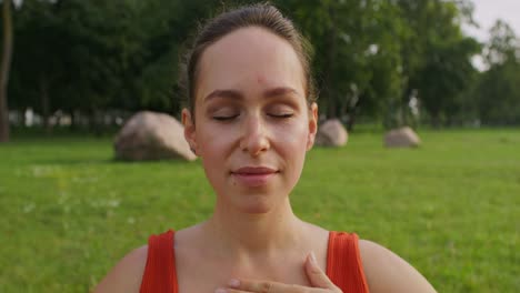 mujer embarazada meditando en el parque