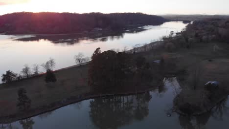 pan over lake and land seeing all the boats below with sunset in background