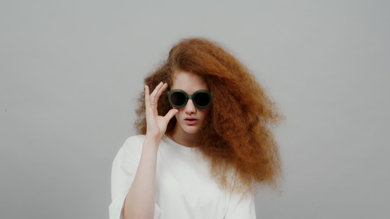 은 곱슬머리와 선글라스를 입은 여자