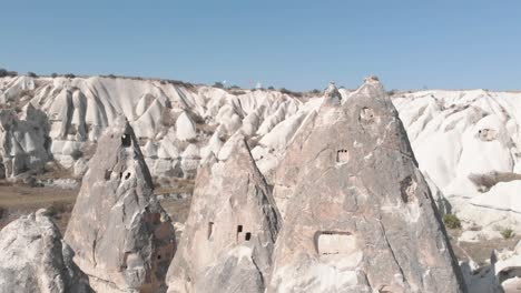 Cappadocia,-Turkey-with-deep-valleys-and-soaring-rock-formations-dotted-with-homes,-chapels,-tombs,-temples-and-entire-subterranean-cities-harmoniously-carved-into-the-rock-formations