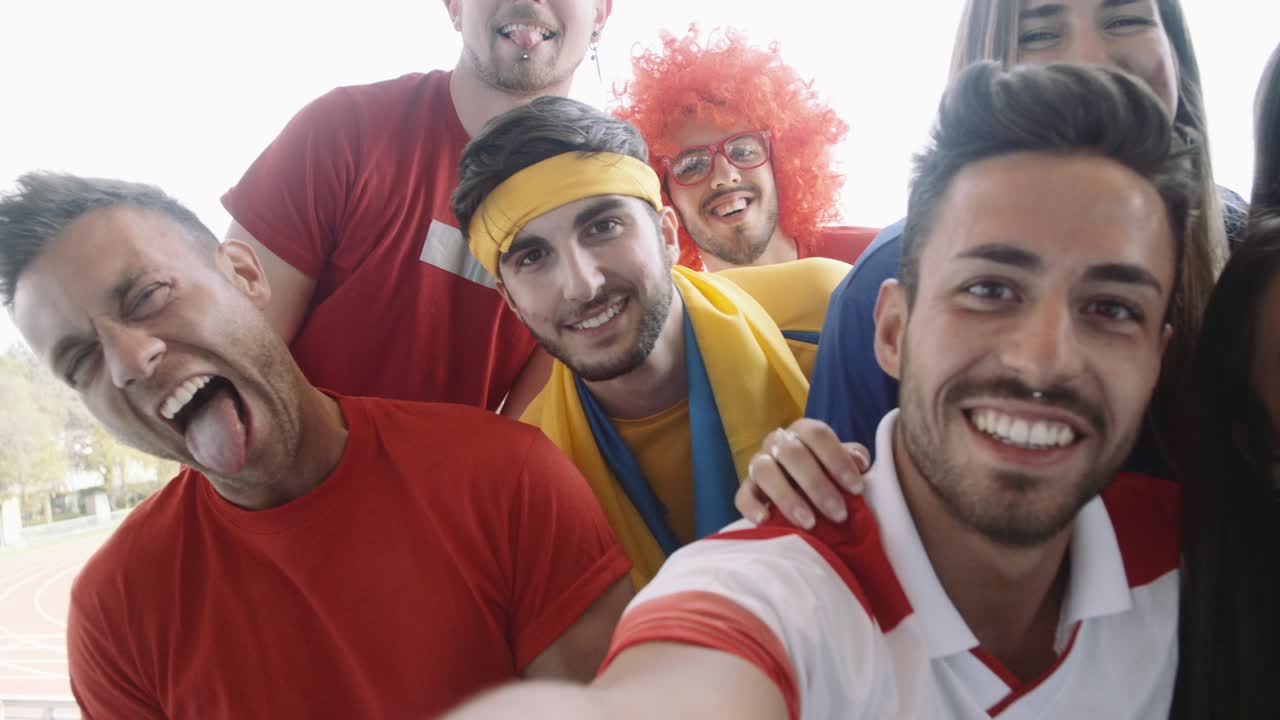 un grupo de aficionados al deporte tomando selfies, filmados en cámara lenta.