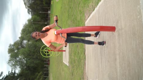 Die-Frau-Benutzt-Im-Park-Ein-Handpedal-Trainingsgerät-–-Vertikale-Aufnahme