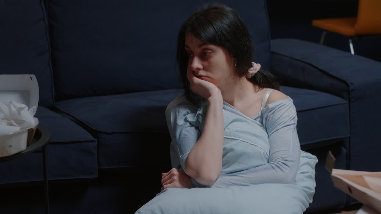 Unhappy woman sitting on floor thinking at problems, suffering from anxiety