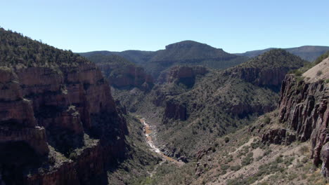 aerial view flying through a rocky canyon, sunny day in superior, arizona, usa