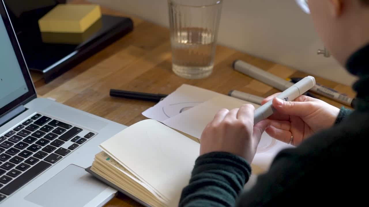 Product designer sketching in a notebook
