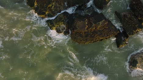 beautiful aerial establishing view of karosta concrete coast fortification ruins, vibrant sunset over stormy baltic sea, winter evening, ascending slow motion birdseye drone shot