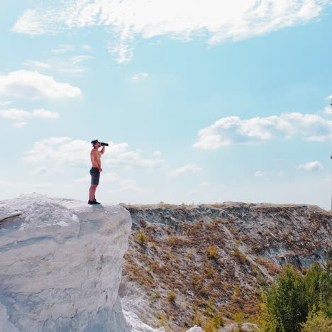 brutal strong bodybuilder posing outdoor. photoshoot in a quarry. outdoor sports concept. aerial view. handsome strong man drinks water outdoor. white landscape.