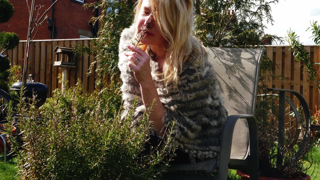 매력적인 여성이 정원에서 신선한 로즈마리 허브를 채집 중간 4k 느린 동작