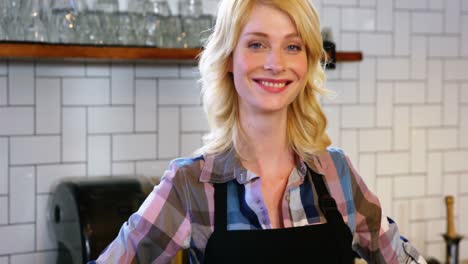 portrait of waitress standing at counter with bread loaf