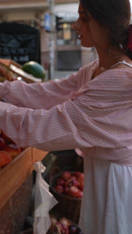 woman shopping for peaches at an outdoor fruit market