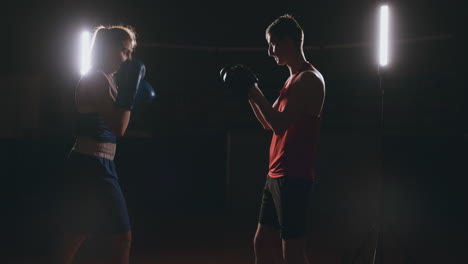 young adult woman doing kickboxing training with her coach.