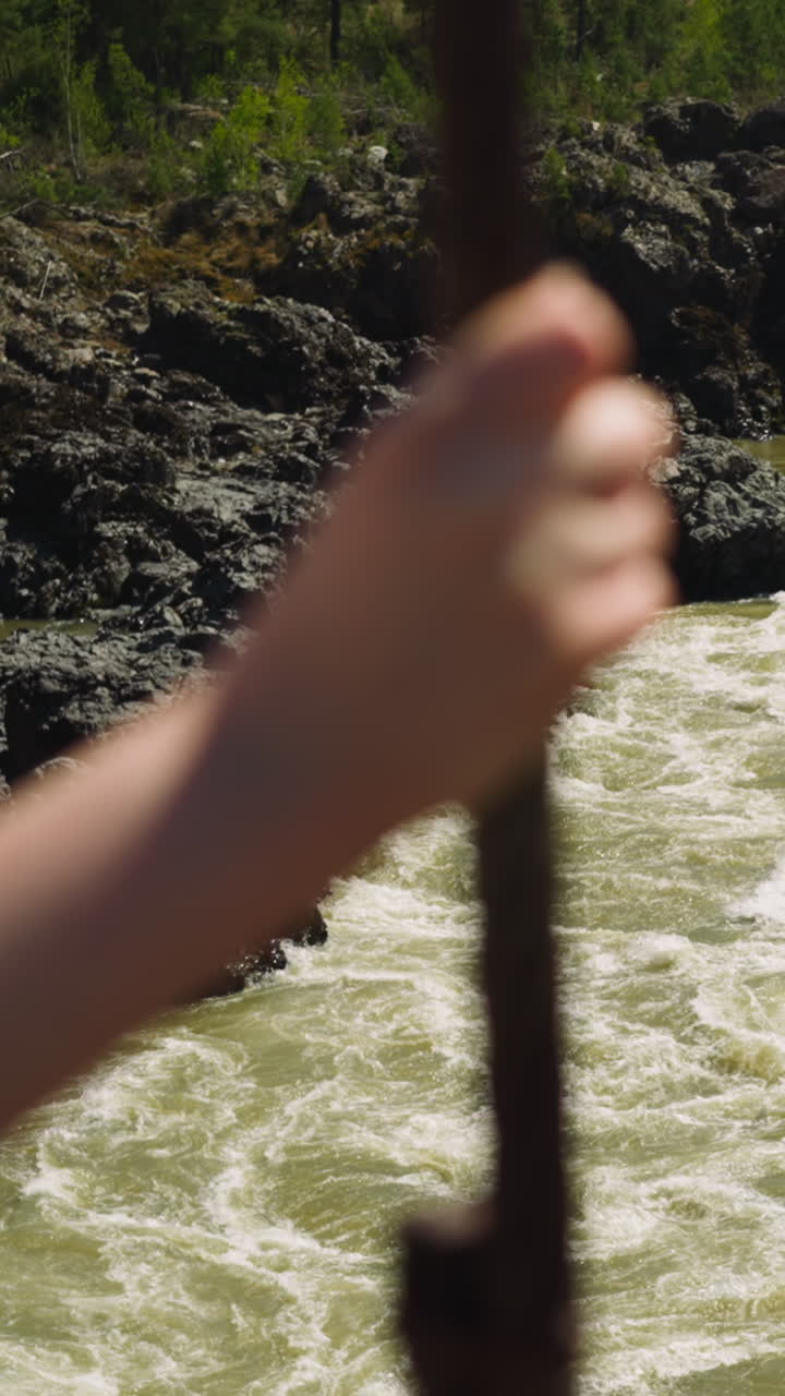 Mountain creek with foamy water and rocky banks view from bridge. Tourist enjoys nature beauty. River in highland ravine in summer
