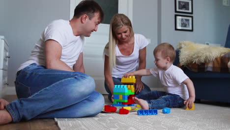 Glückliche-Familie,-Vater,-Mutter-Und-Baby-2-Jahre,-Die-In-Ihrem-Hellen-Wohnzimmer-Lego-Spielen.-Zeitlupenaufnahmen-Einer-Glücklichen-Familie