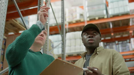 warehouse workers discussing inventory with clipboard
