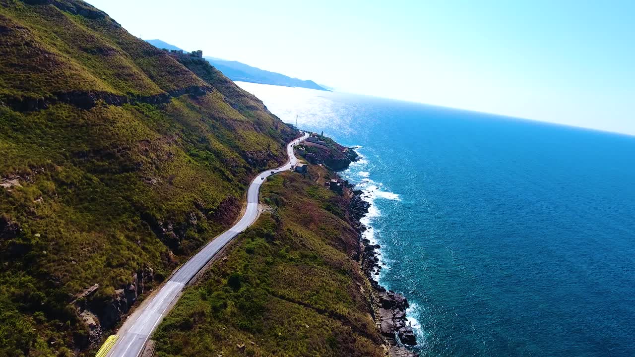 산과 바다 사이의 절벽 쪽에 있는 도로의 공중 드론  ⁇