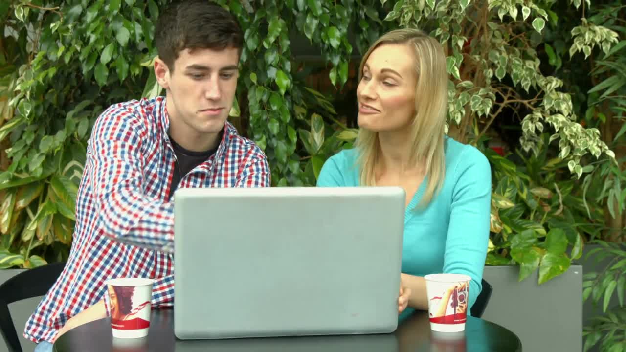 estudiantes usando computadoras portátiles afuera en el campus