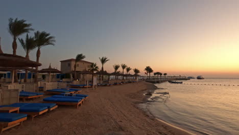 Serene-beach-resort-with-huts-and-sunbeds-at-dusk