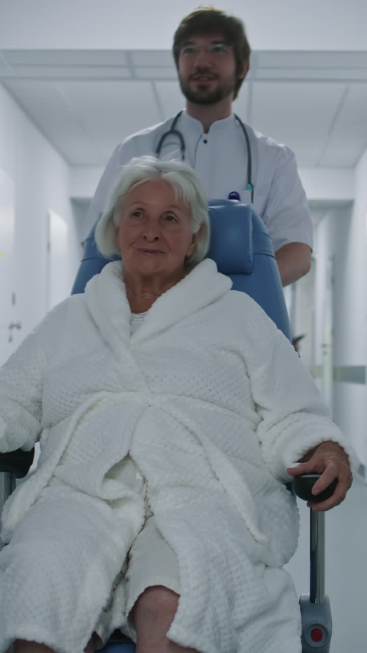 paciente anciano transportado por personal médico en el pasillo del hospital
