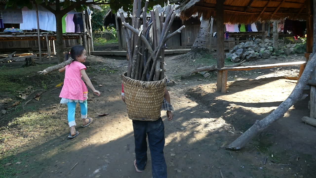 Children Carrying Wood in a Village