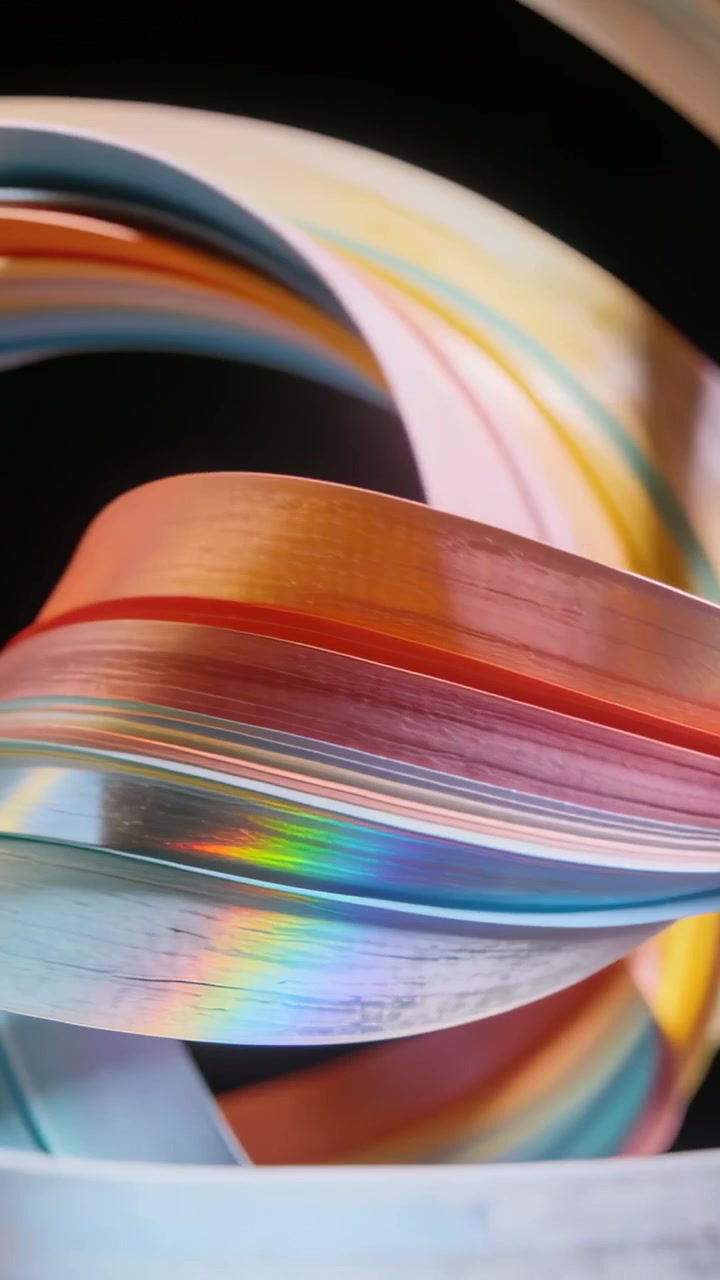 Vertical video: Light striking iridescent ribbon twisting and revealing banded colors on dark set