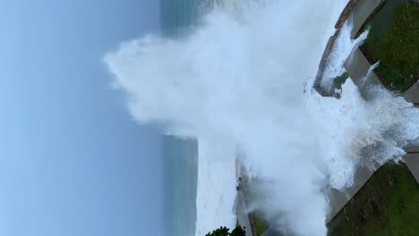 crashing wave explodes into sky as hurricane beryl pass through, vertical aerial