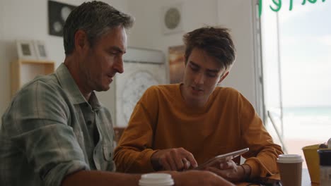 padre y joven hijo adulto socializando juntos