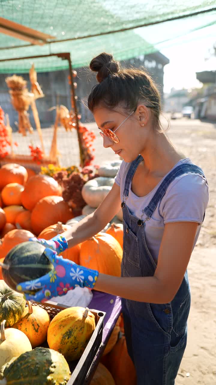 joven comprando calabazas en un mercado de otoño