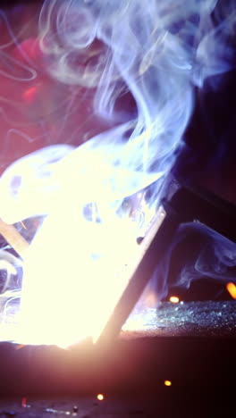 primer plano de un soldador trabajando en una pieza de metal
