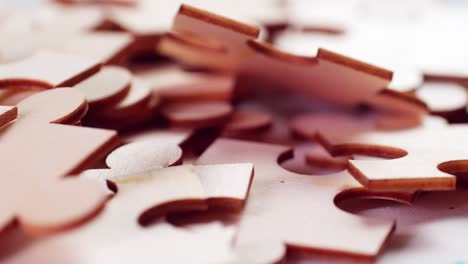 a closeup of jigsaw puzzle pieces placed on a turning table revealing pieces exposed to light and creating shadows